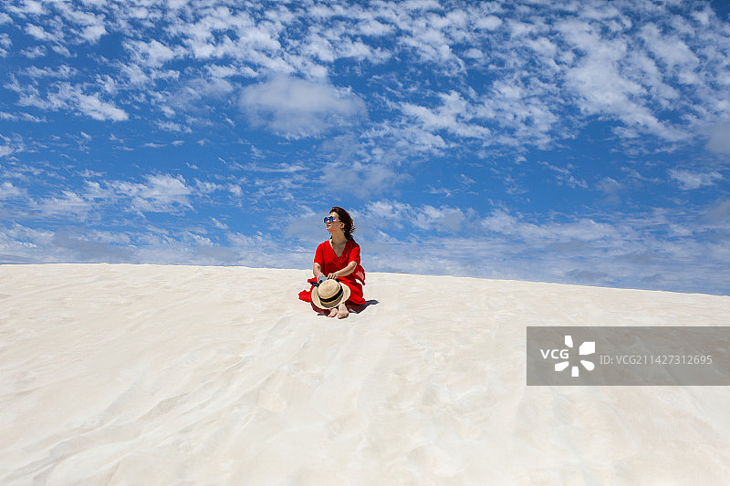 坐在一望无际白沙漠上的女人图片素材