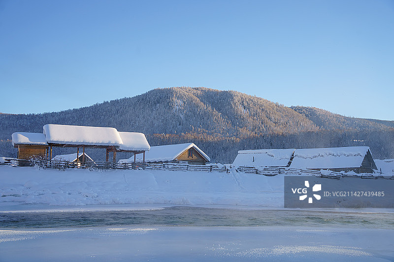 新疆阿勒泰禾木村冬日冻结的禾木河和村庄图片素材