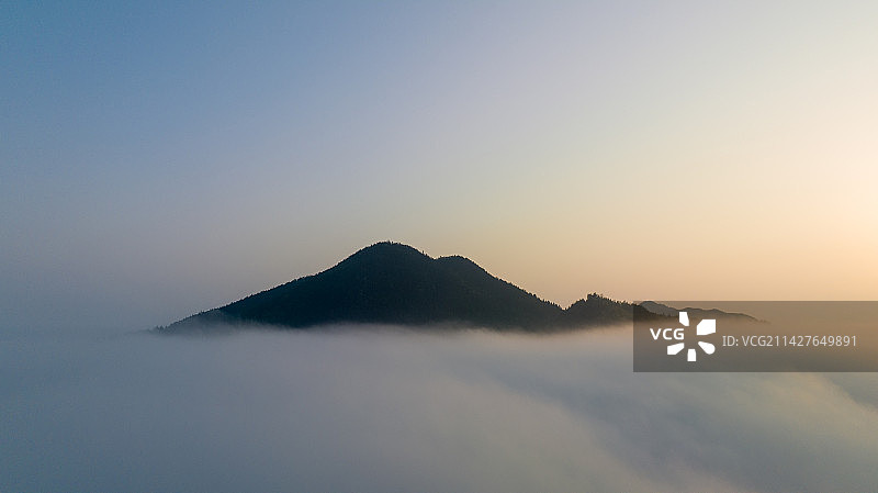 朝霞中云海里的一座山峰图片素材