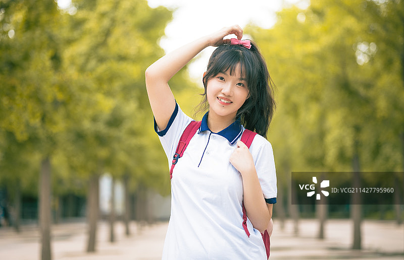 站在公园里微笑的年轻女子的画像图片素材