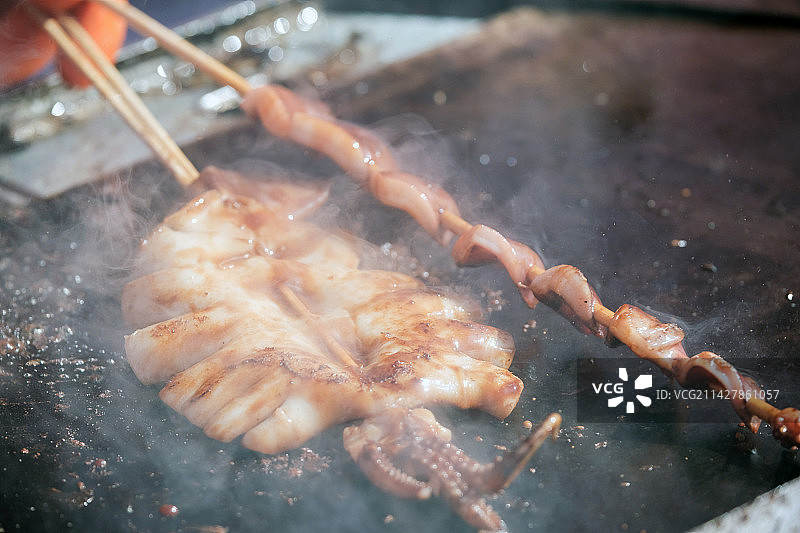 正在烤制的铁板鱿鱼铁板鱿鱼须特写图片素材