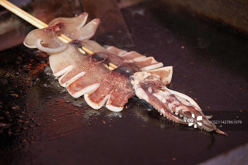 正在烤制的铁板鱿鱼铁板鱿鱼须特写图片素材