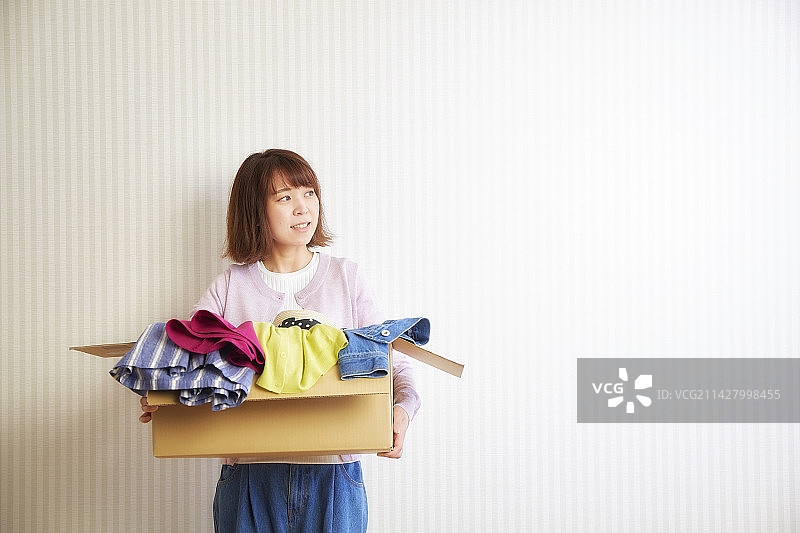 在纸板箱里携带衣服的女人图片素材