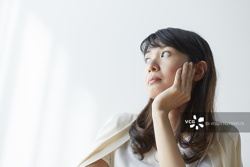 露出颧骨向窗外看的女人图片素材