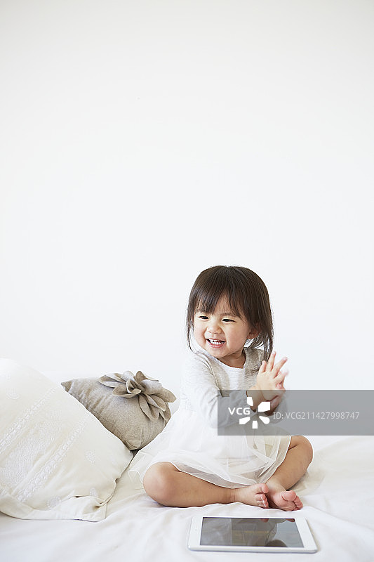 床上拍手的宝宝。图片素材