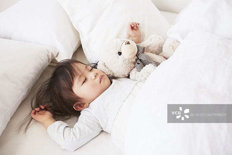 宝宝在床上和毛绒玩具一起睡觉图片素材