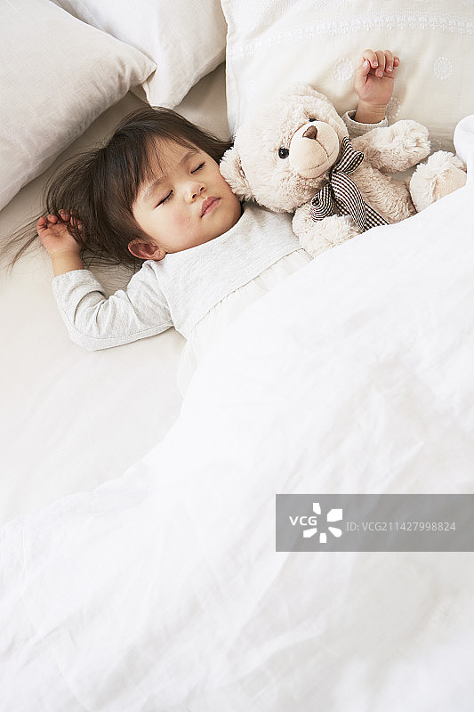宝宝在床上和毛绒玩具一起睡觉图片素材