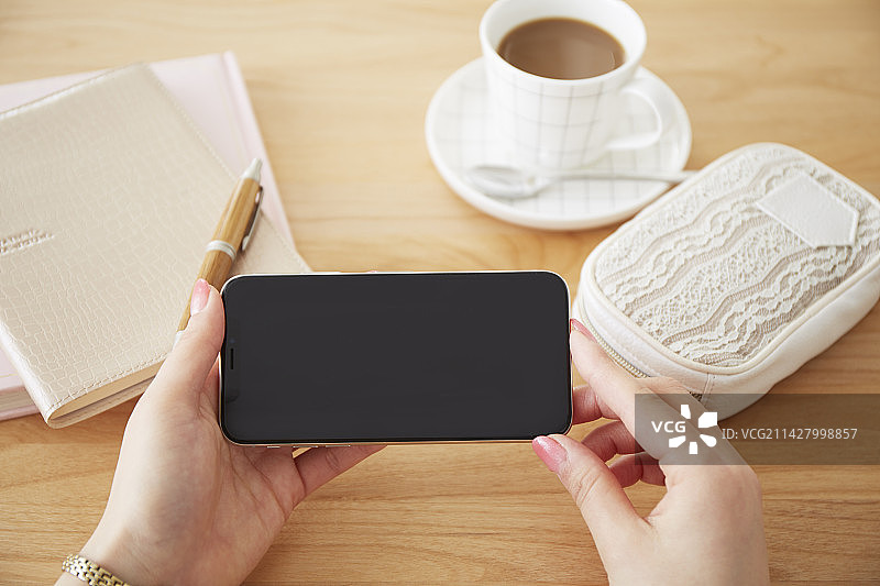 女人在桌上使用智能手机图片素材