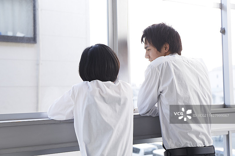 高中男生和女生在窗边聊天图片素材