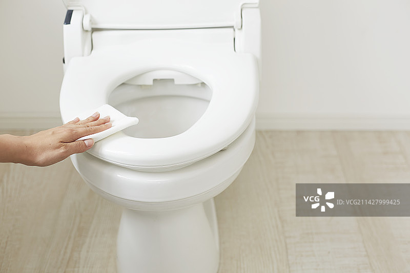 女人用纸巾擦拭马桶座图片素材