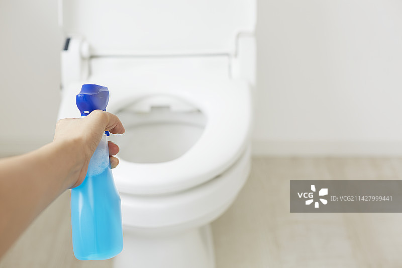 女人用喷雾清洁马桶图片素材