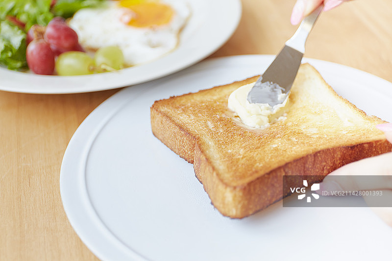在桌子上涂抹黄油图片素材