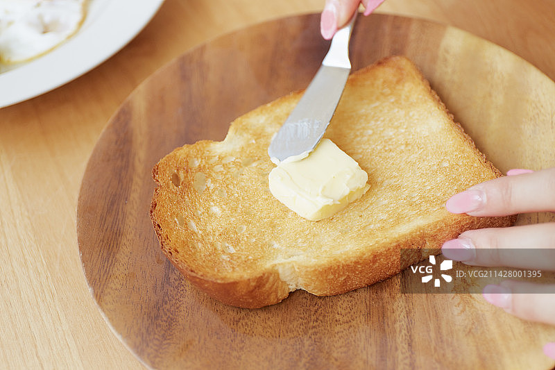 在桌子上涂抹黄油图片素材