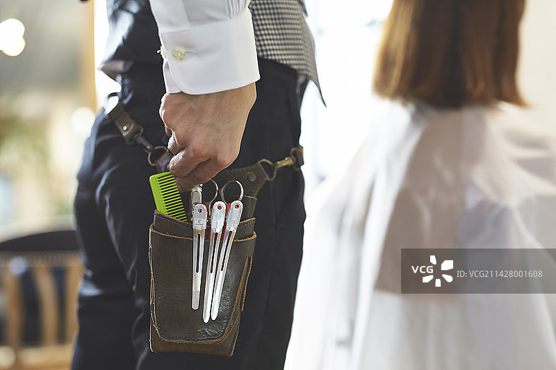 美发师手拿腰包里的工具图片素材
