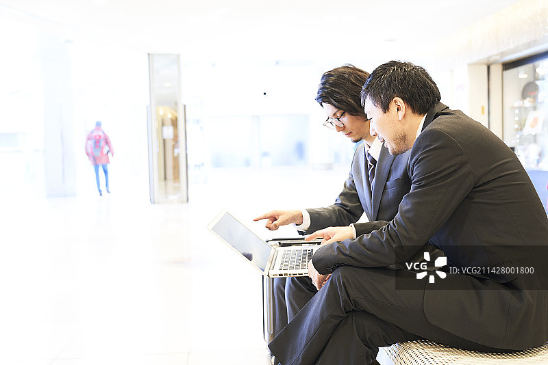 商务人士在机场打开笔记本电脑图片素材