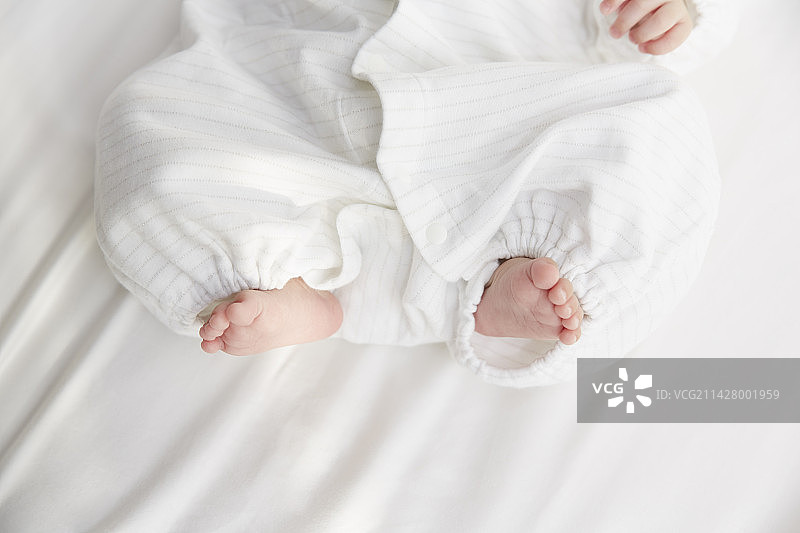 在白色床单上睡觉的婴儿的脚图片素材