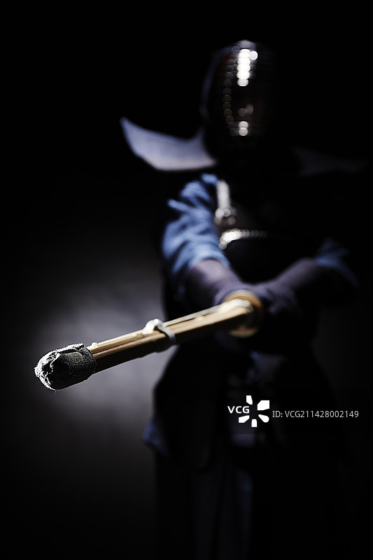 一位穿着道服的男人挥舞竹剑图片素材