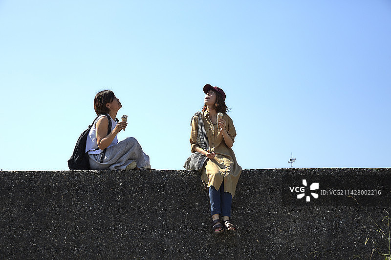 两位女人在岸边吃冰淇淋图片素材