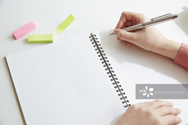 女人手拿笔记本、便签和笔图片素材