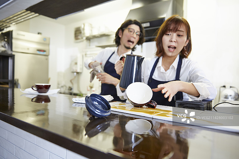 女服务员不小心打翻咖啡，男服务员惊慌失措图片素材