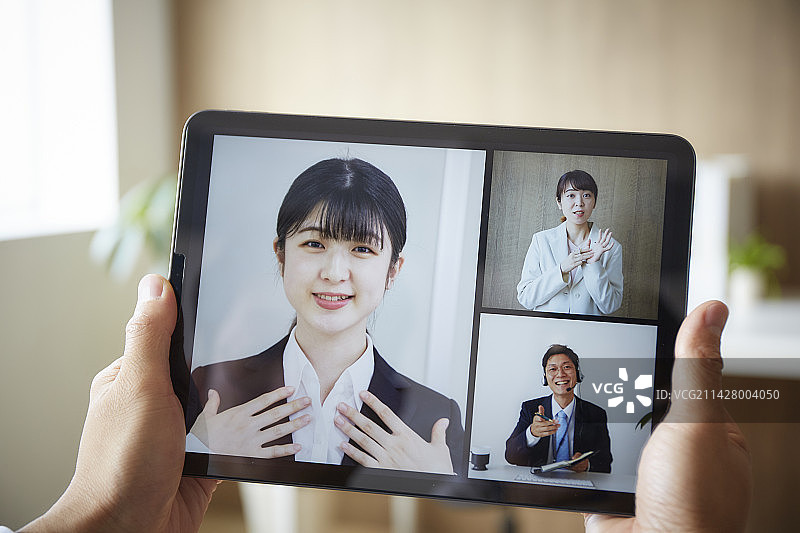 远程会议中平板电脑和男人的手图片素材
