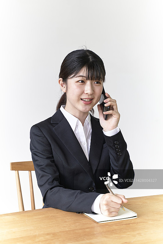 正在打电话并记录笔记的求职女人图片素材
