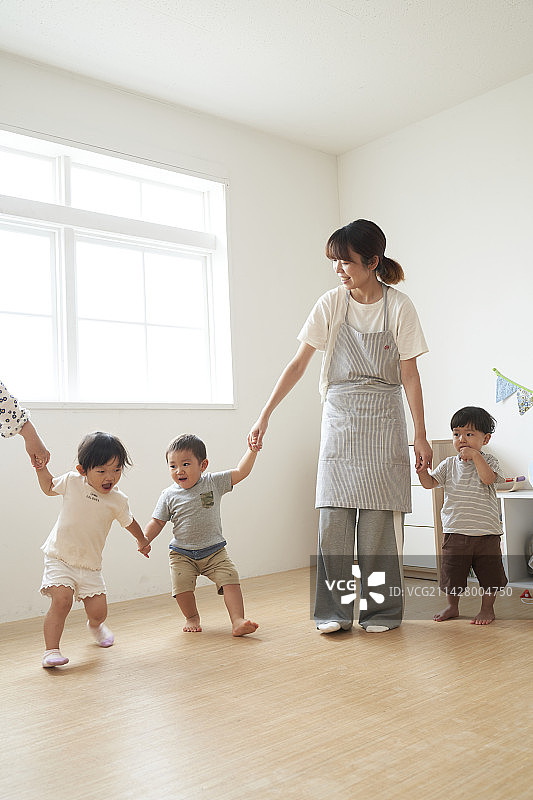 女幼教牵着孩子们的手图片素材