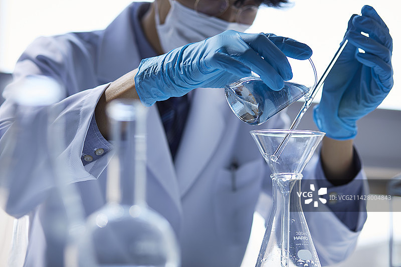 身穿白色实验服在白色空间做实验的男人图片素材