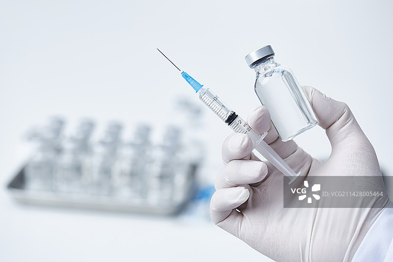 研究人员手持疫苗和注射器图片素材