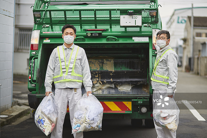 垃圾车和正在收集垃圾的男性工人图片素材
