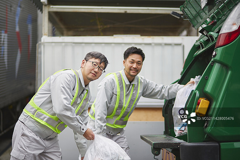 男工人用垃圾压缩车收集垃圾图片素材