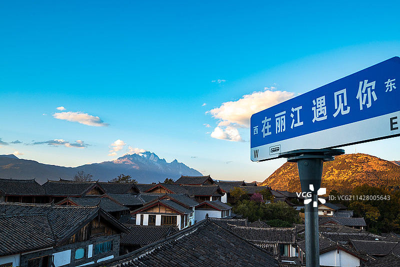 云南丽江古城房屋屋顶客栈和玉龙雪山白昼清晨日出图片素材