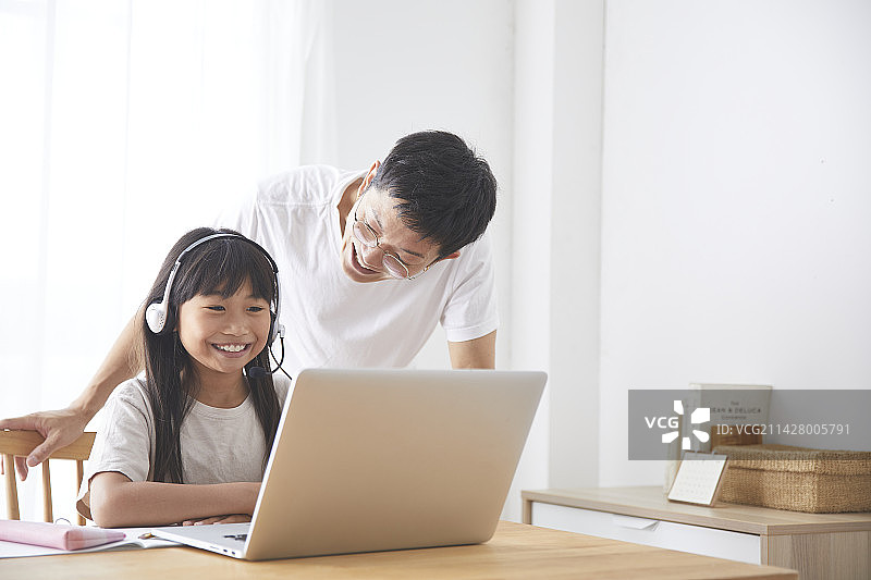 女孩和父亲在餐厅上网课图片素材