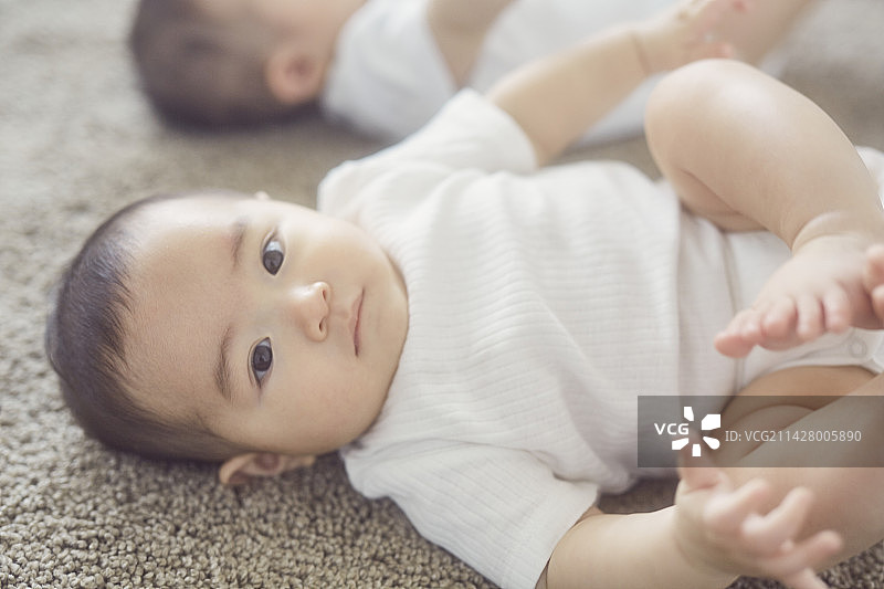 躺在米色地毯上的宝宝图片素材