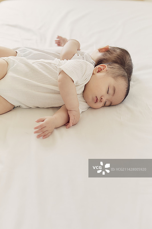 双胞胎宝宝在床上背靠背睡觉图片素材