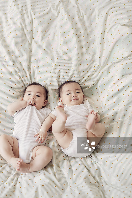 躺在简易床上的婴儿双胞胎图片素材