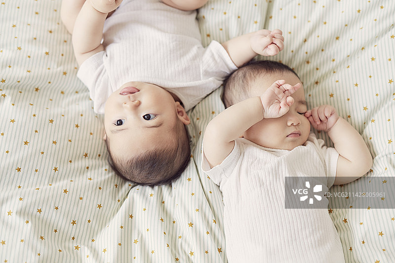 躺在日式床垫上的双胞胎婴儿图片素材