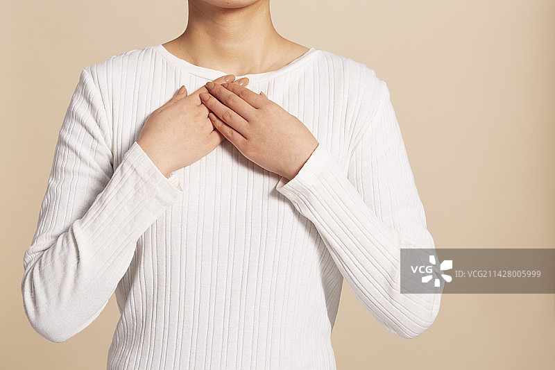 双手放在胸前的白衣女人图片素材
