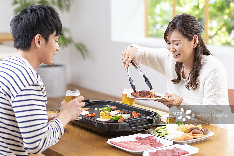 情侣吃烤肉喝生啤酒图片素材