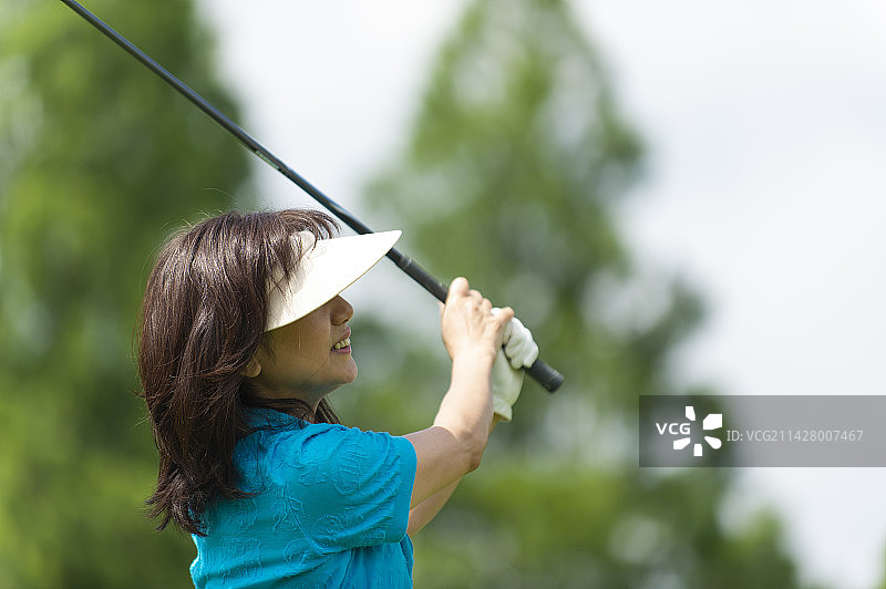 中年妇女打高尔夫球图片素材