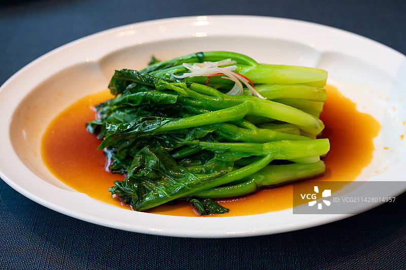 一盘白灼芥兰放在桌子上图片素材