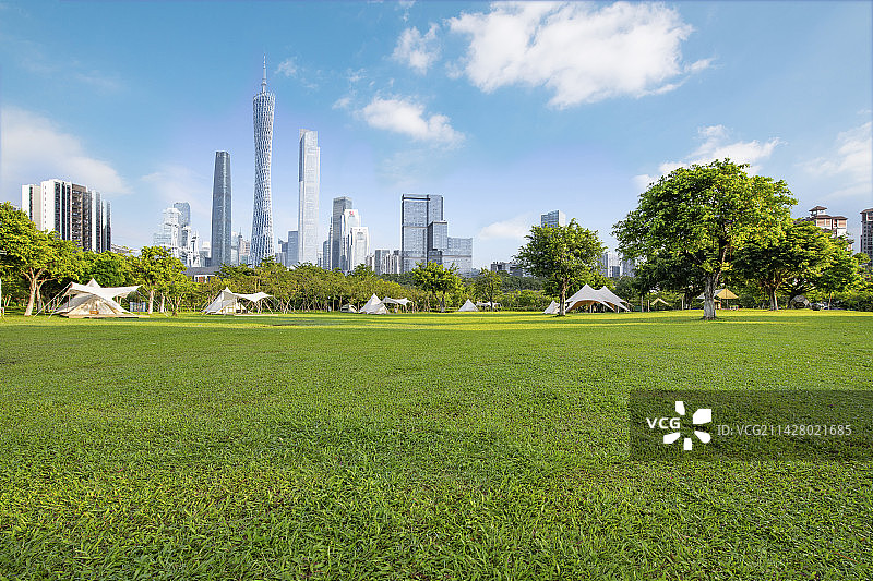 清晨蓝天白云下的广州塔和公园露营草地图片素材