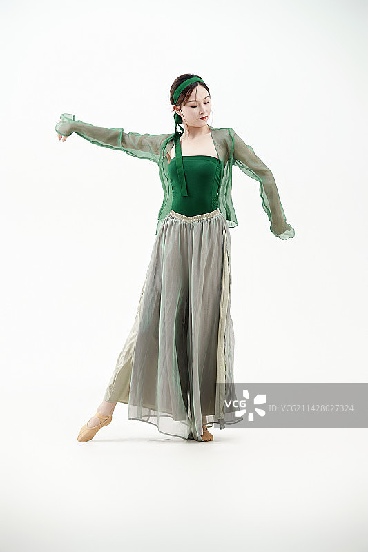 身穿青色古典舞蹈服装手拿蒲扇跳舞的少女图片素材