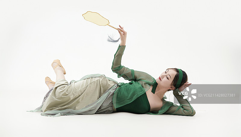 身穿青色古典舞蹈服装手拿蒲扇跳舞的少女图片素材