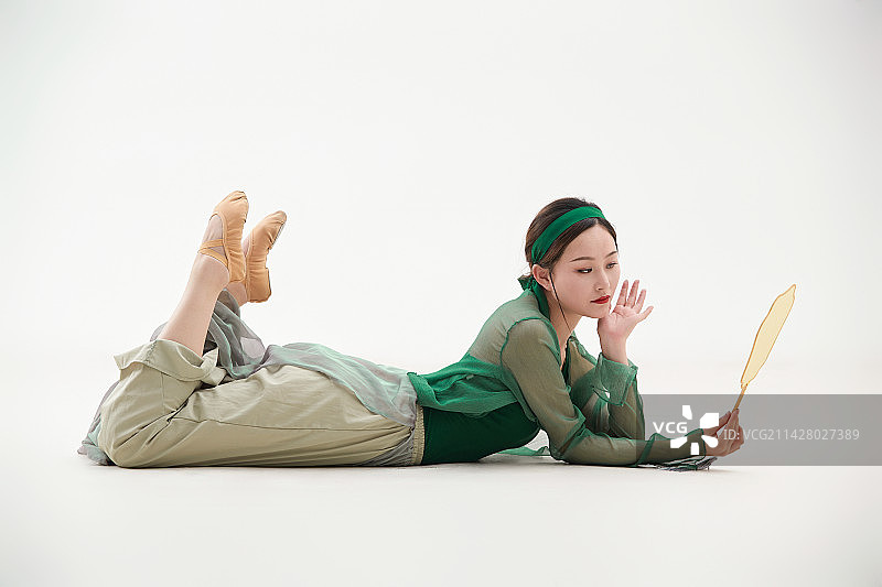 身穿青色古典舞蹈服装手拿蒲扇跳舞的少女图片素材