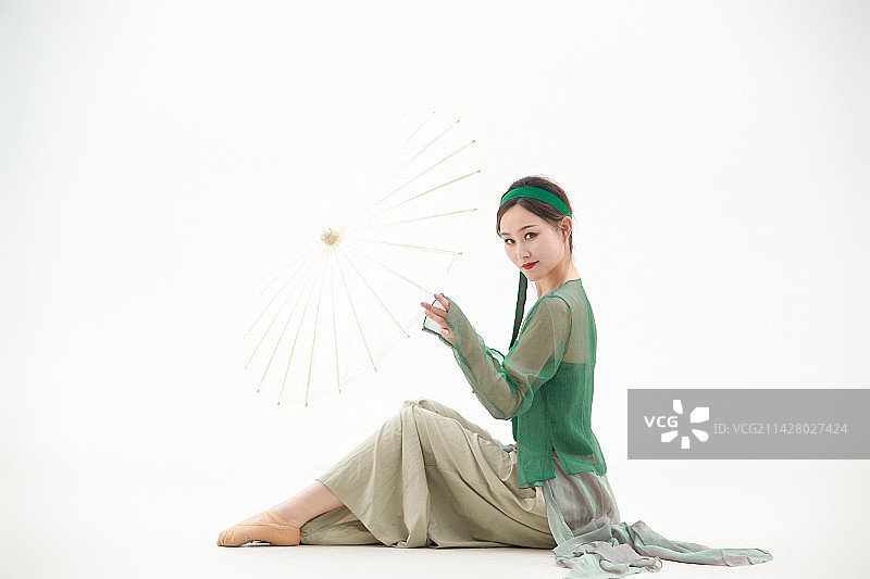 身穿青色古典舞蹈服装手拿蒲扇跳舞的少女图片素材