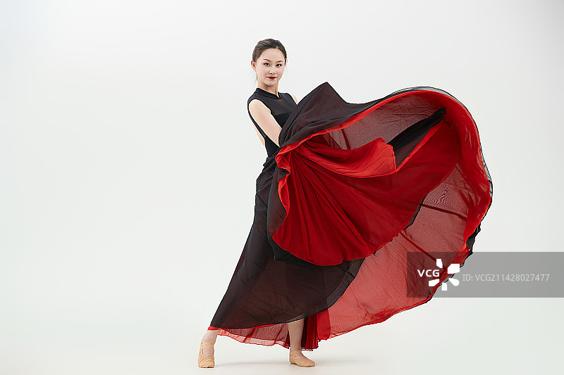 身穿红黑相间的舞蹈长裙翩翩起舞的少女图片素材