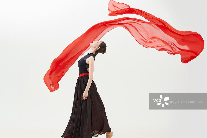 身穿红黑相间的舞蹈长裙翩翩起舞的少女图片素材