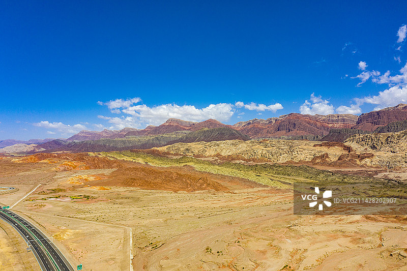 航拍新疆戈壁滩上的丹霞地貌与高速公路图片素材