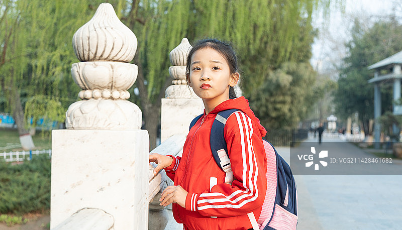 户外背着书包的小学女生肖像特写图片素材